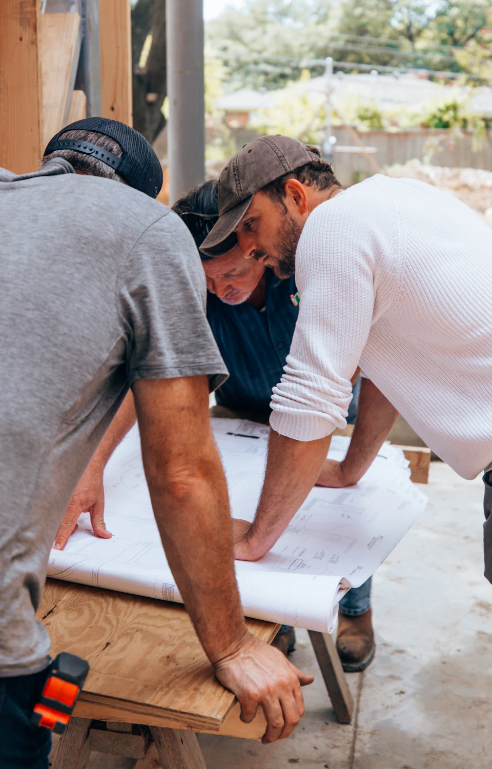 Zwei Handwerker besprechen einen Plan in ihrer Werkstatt